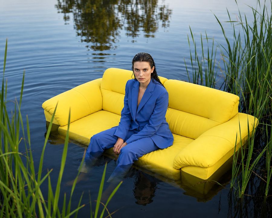 Model seated on a yellow sofa floating on water in an AI-generated campaign visual